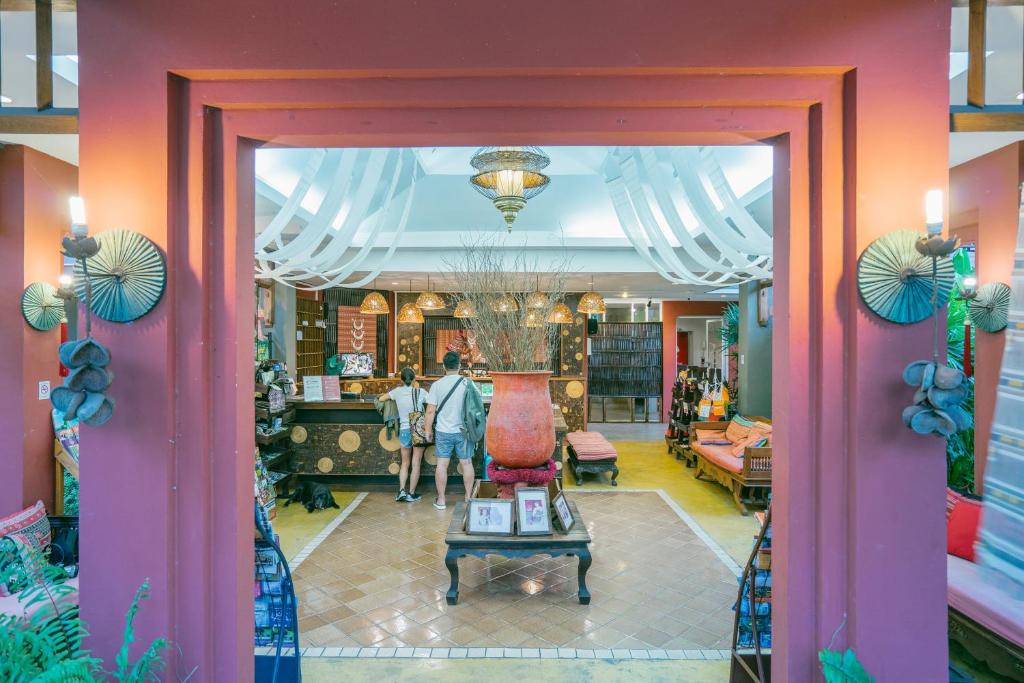 A colorful lobby entrance framed by a pink doorway and eclectic decor.