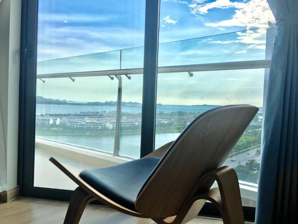 een stoel voor een groot raam bij Angela House Ha Long in Ha Long