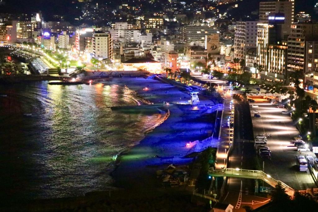 a view of a city at night with a river at Guest House MARUYA in Atami