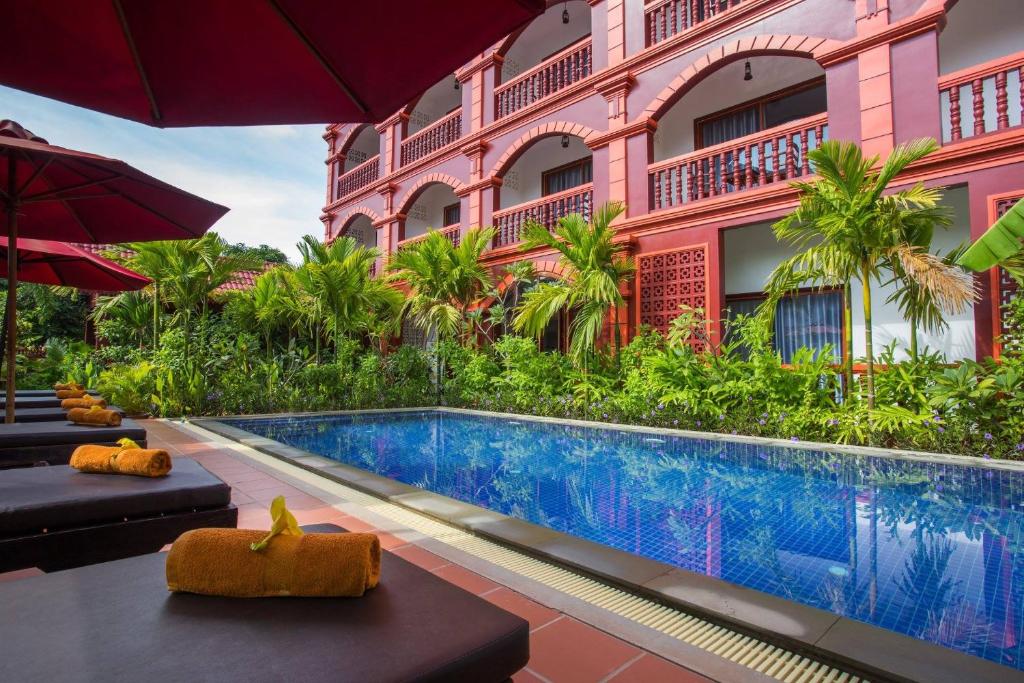 a hotel with a swimming pool in front of a building at Bou Savy Villa in Siem Reap