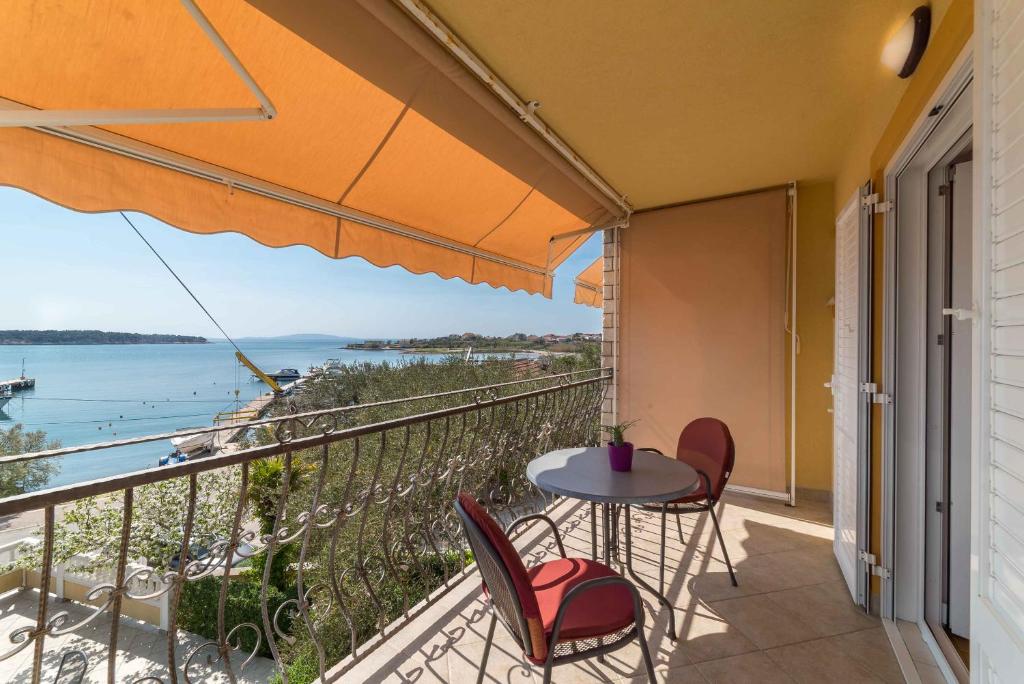a balcony with a table and chairs and a view of the ocean at Captain's Club in Rab
