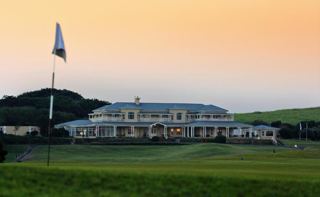 ein großes Haus auf einem Golfplatz mit Flagge in der Unterkunft The Lodge at Prince's Grant Coastal Golf Estate in Blythedale