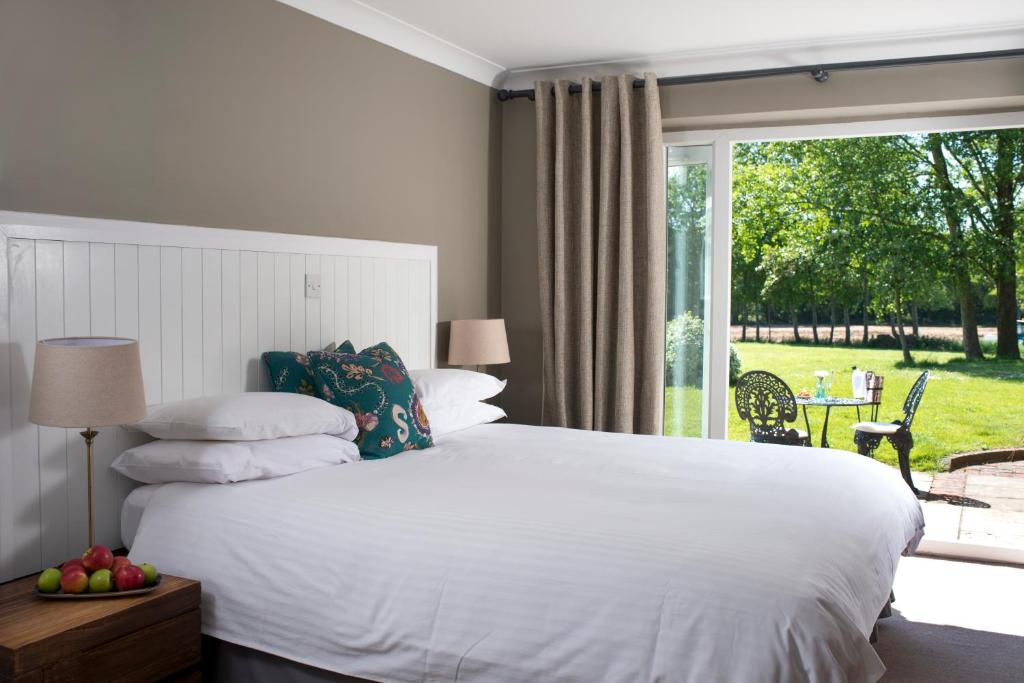 a bedroom with a white bed and a large window at Crouchers Hotel in Chichester