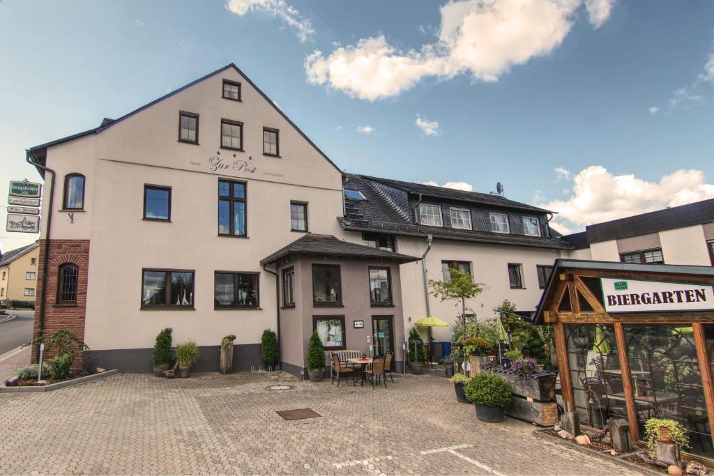 a large white building in front of a building at Landgasthof Zur Post in Zilshausen