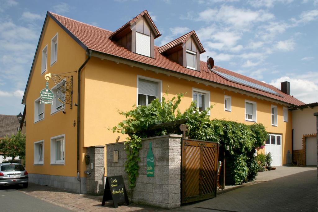 ein gelbes Haus an der Seite einer Straße in der Unterkunft Weingut Herbert Kram in Nordheim