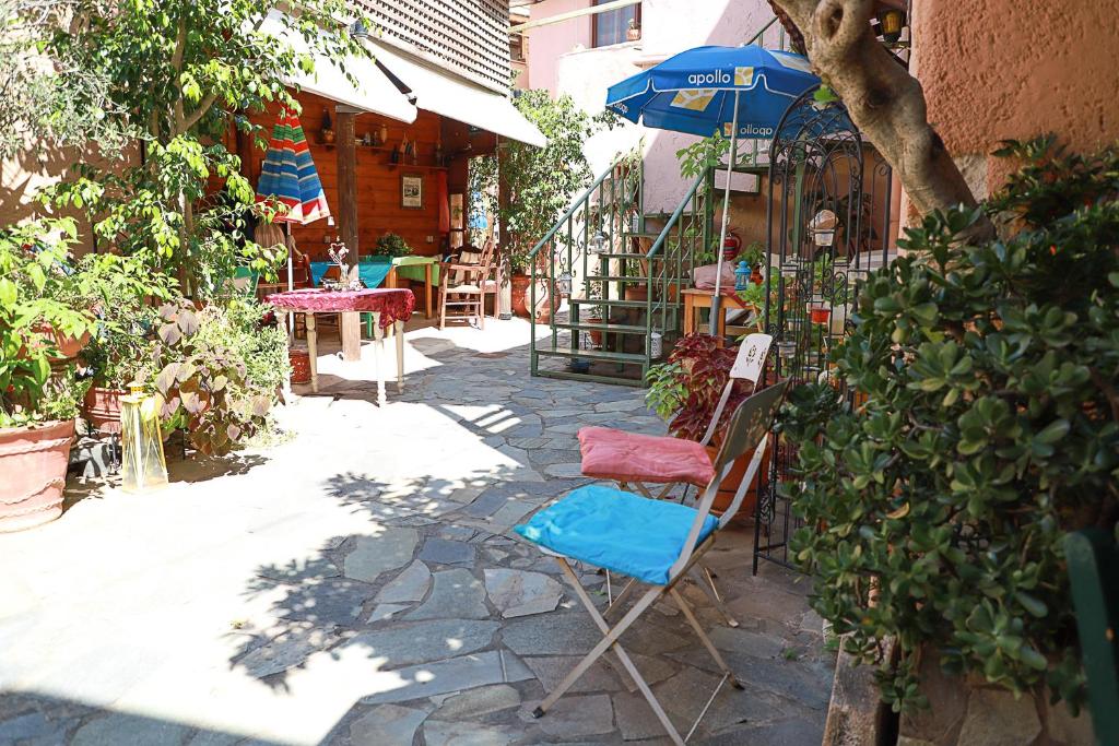 Pazinos的住宿－Pazinos Village Studios，庭院里摆放着几把椅子和一把遮阳伞