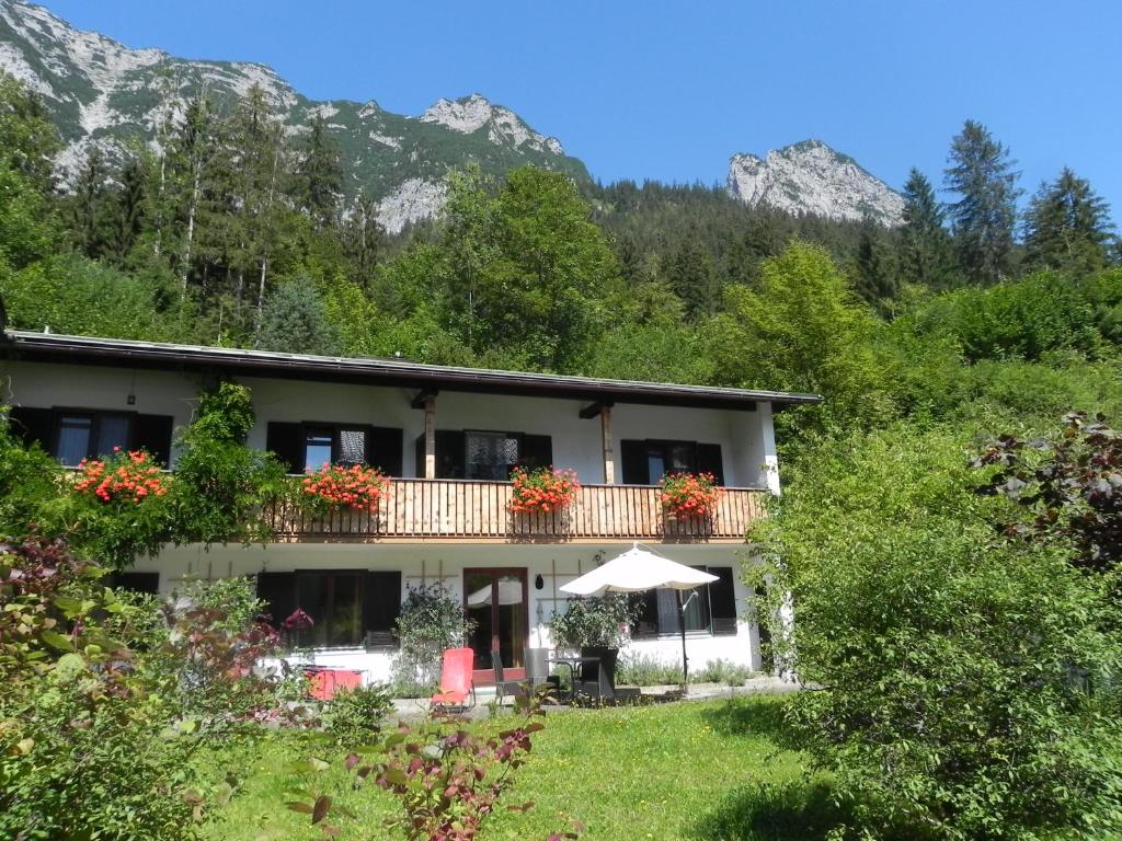 ein Haus mit Balkon und Bergen im Hintergrund in der Unterkunft Ferienwohnungen Reiteralpe in Ramsau bei Berchtesgaden