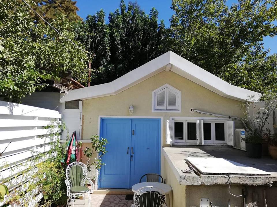 mały dom z niebieskimi drzwiami na dziedzińcu w obiekcie Swallows Nest w Larnace