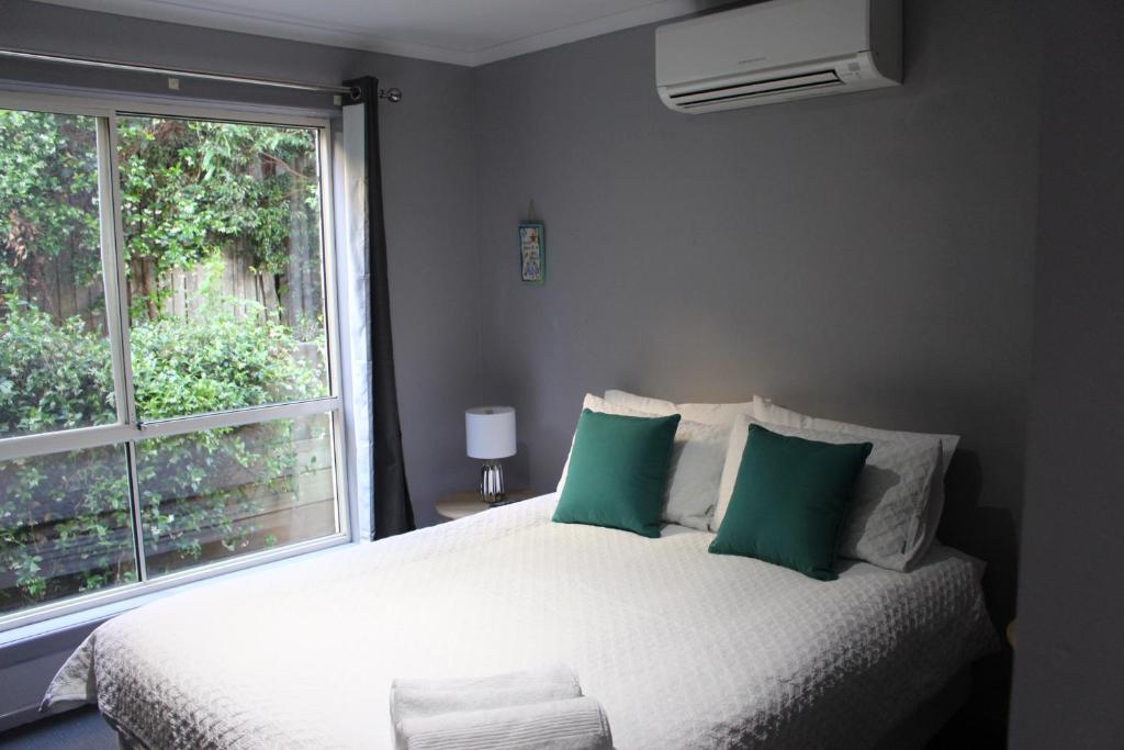 a bedroom with a bed and a window at Aqualuna Apartments in Coffs Harbour