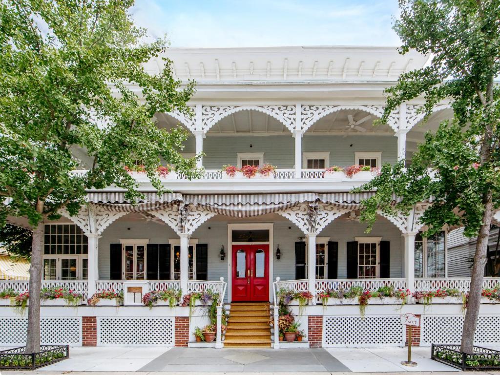 una casa bianca con una porta rossa di The Virginia and Cottages a Cape May