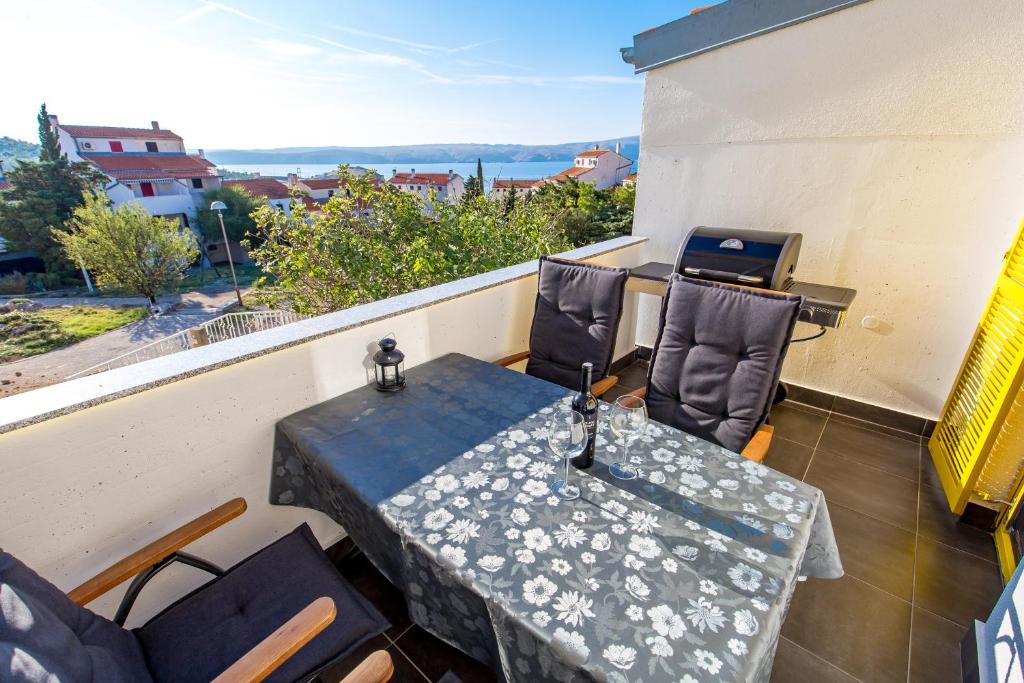 a table and chairs on a balcony with a grill at Apartment "Santa Lucia" in Stinica