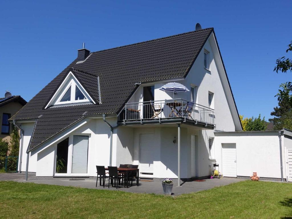 a large white house with a black roof at Ferienwohnung Regenbogenhaus in Hasselberg