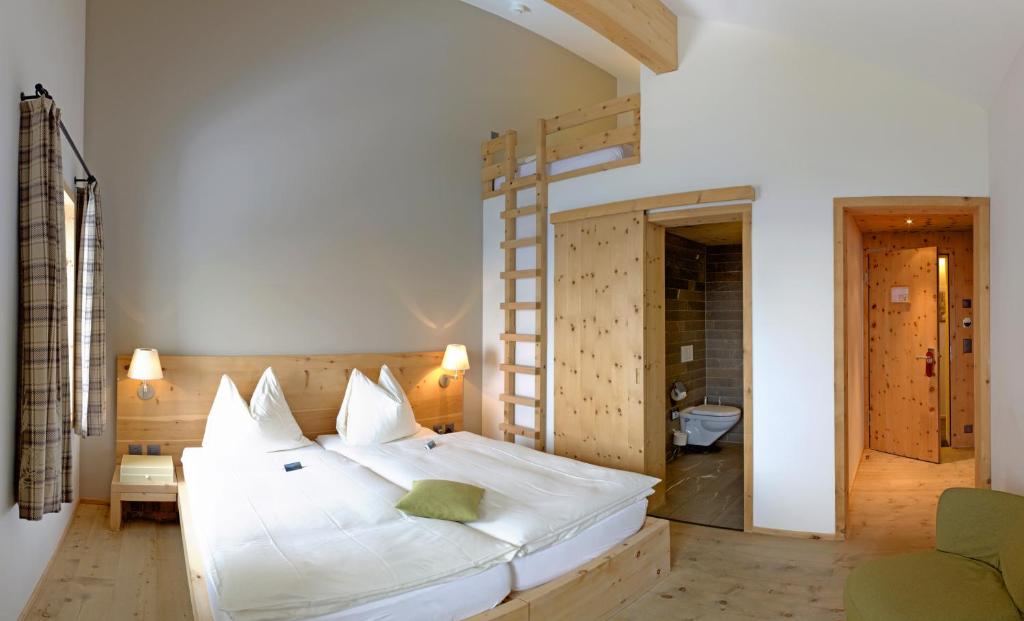 Postel nebo postele na pokoji v ubytování Romantik Hotel Muottas Muragl