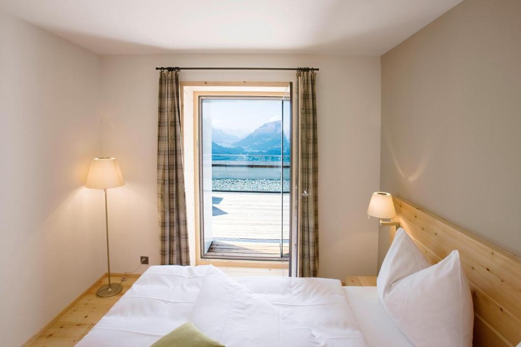 Postel nebo postele na pokoji v ubytování Romantik Hotel Muottas Muragl