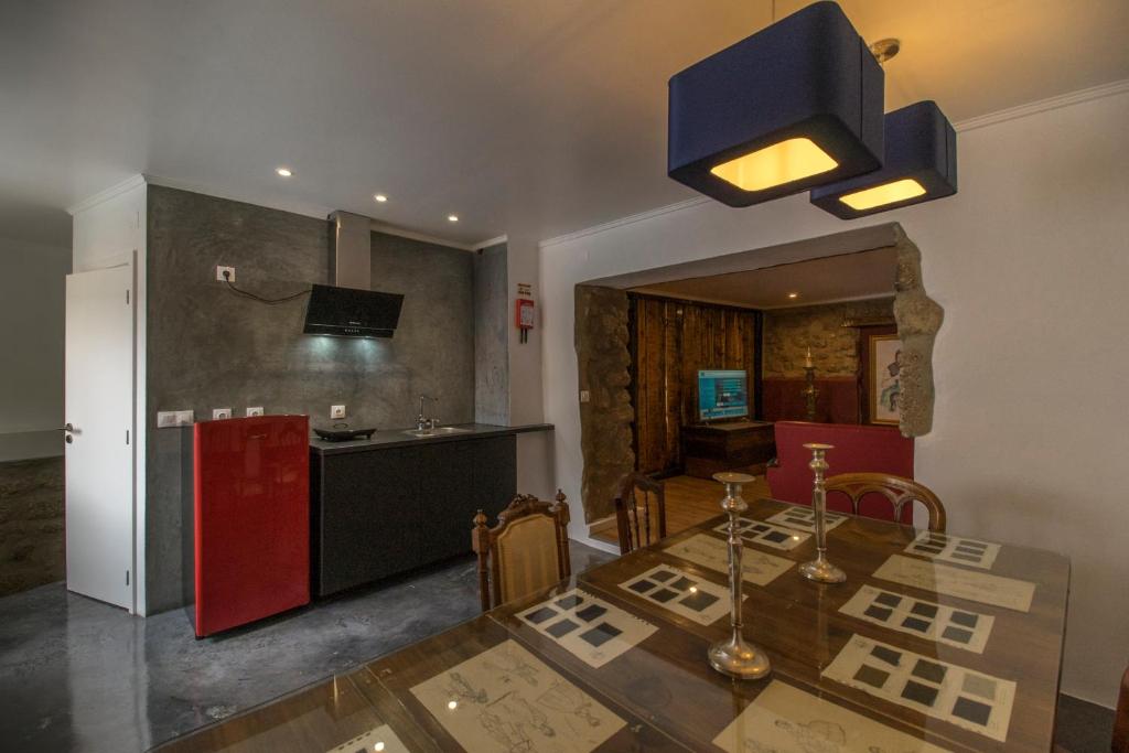 a kitchen with a dining table and a red refrigerator at Memórias Charme Residences in Covilhã