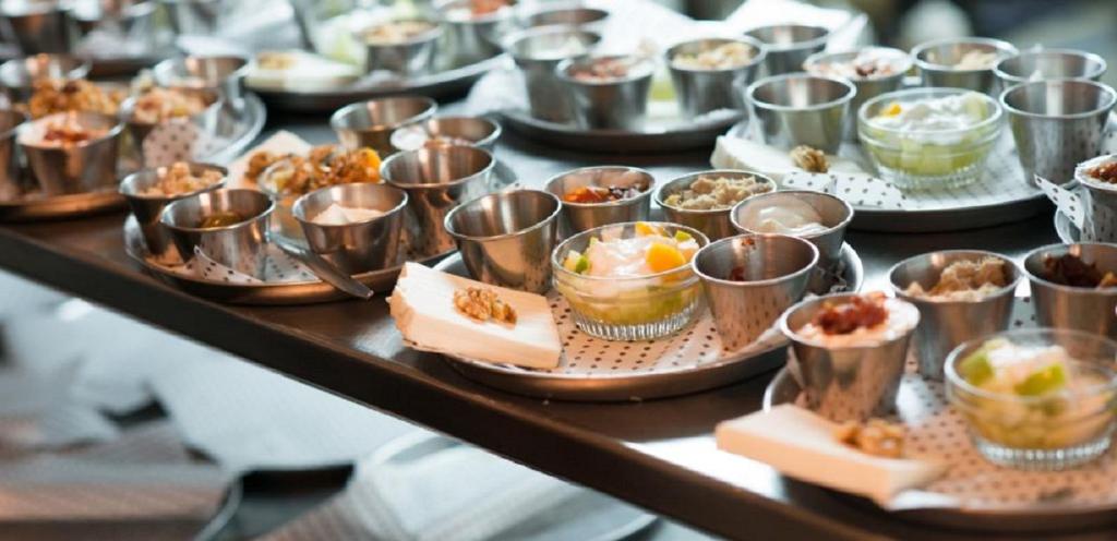a table filled with dishes of food on plates at Villa Brown Moshava - a member of Brown Hotels in Jerusalem
