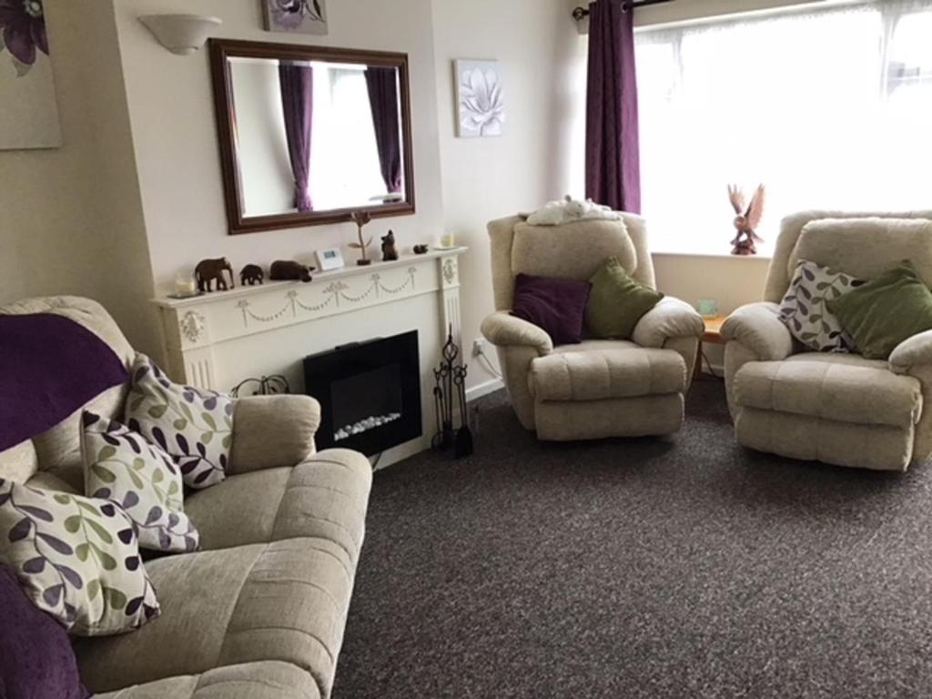 a living room with two couches and a fireplace at 9 Gunfleet court in Clacton-on-Sea