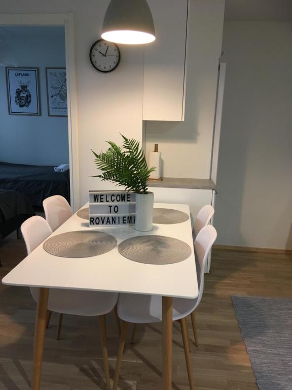 a white dining room table with a plant on it at Siljo Apartments in Rovaniemi