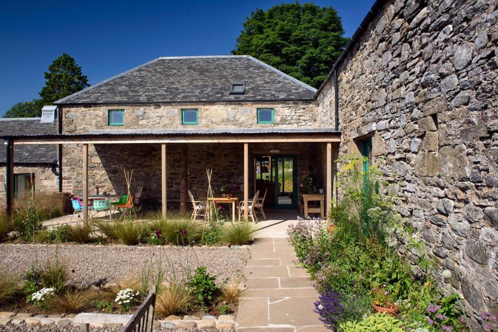 an old stone house with a stone wall at Burmieston in Perth