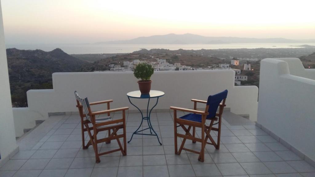 een tafel en stoelen op een balkon met uitzicht bij Vivlos. Maisonette with View in Vívlos