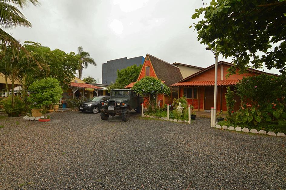 a jeep parked in a parking lot next to a house at Pousada são Francisco do sul-SC in Sambaqui