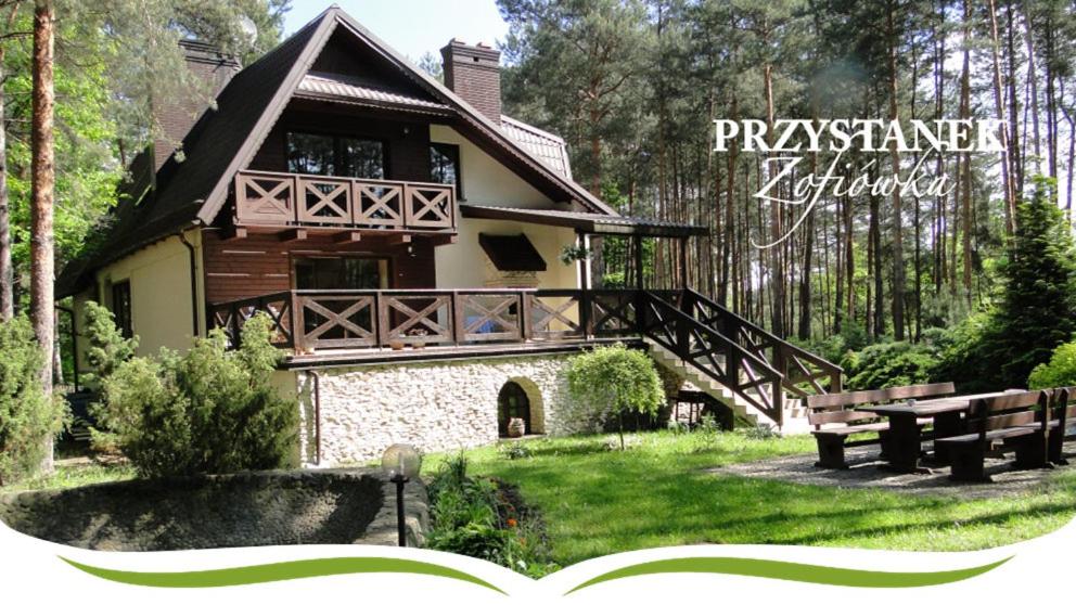 een huis in een park met een picknicktafel en banken bij Przystanek Zofiówka in Tuszyn