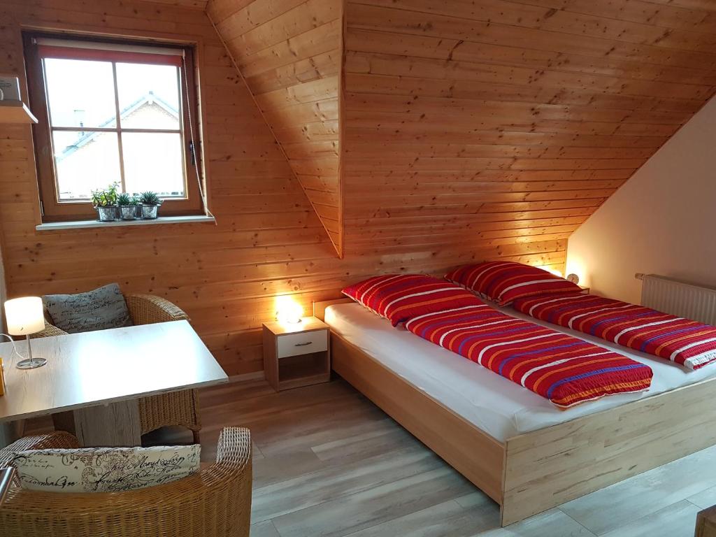 a bed with red pillows in a wooden room at Ferienwohnung Erkelenz in Erkelenz