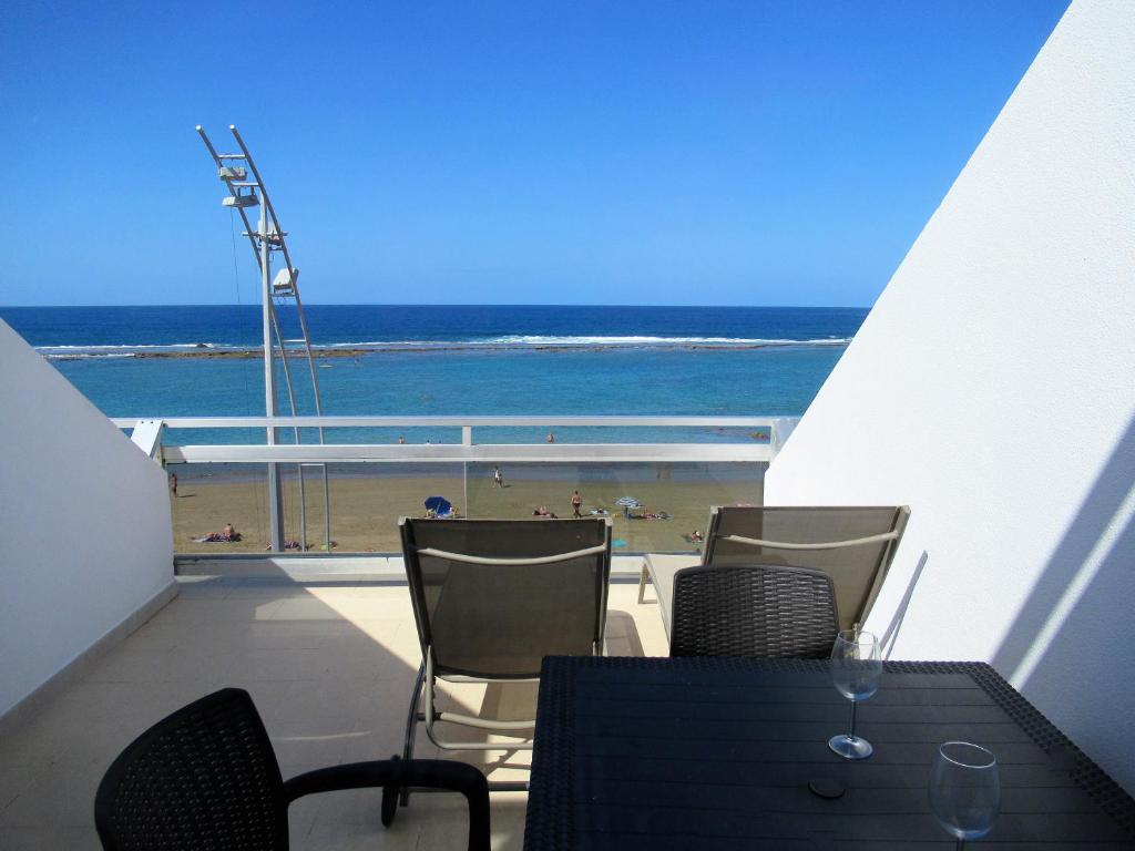 ラスパルマス・デ・グランカナリアにあるApartamento 1ª linea Las Canteras -vista mar con terraza y wifi - 307のビーチの景色を望むバルコニー(テーブル、椅子付)