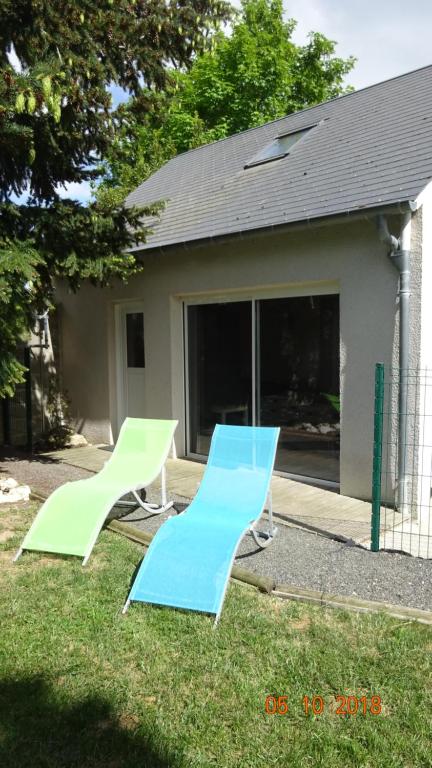duas cadeiras azuis e verdes em frente a uma casa em MAISON DE VILLE Avec jardin et Parking em Blois
