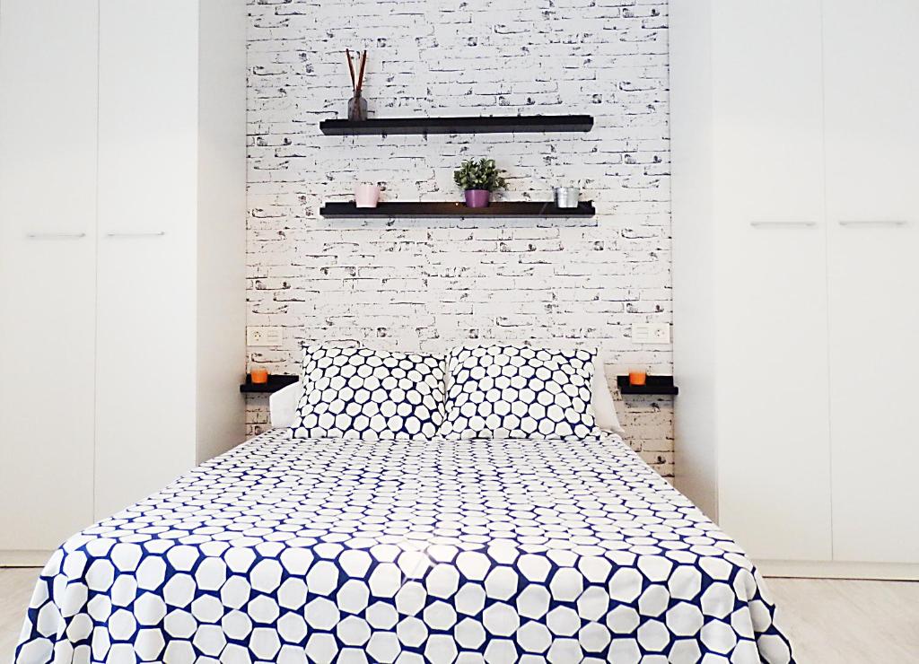 ein Schlafzimmer mit einer weißen Ziegelwand und einem Bett in der Unterkunft Campanar Flat in Valencia
