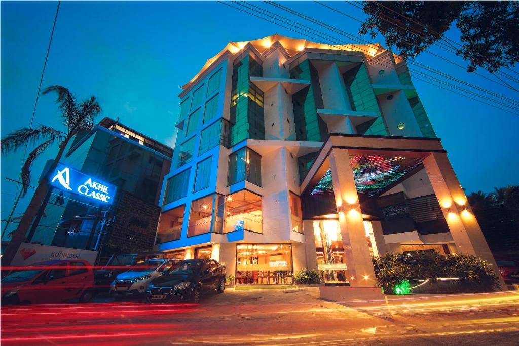um edifício com carros estacionados em frente a ele à noite em Akhil Classic em Trivandrum