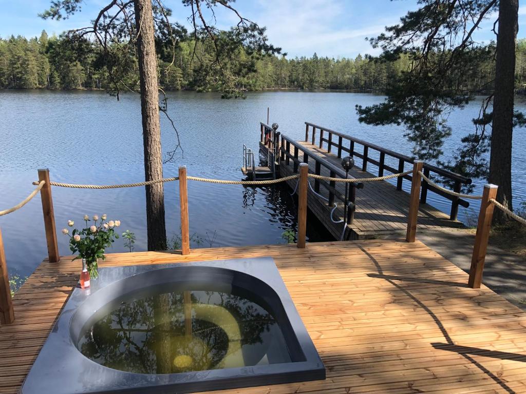 a fire pit on a wooden deck next to a lake at Hotelli Lepolampi in Espoo