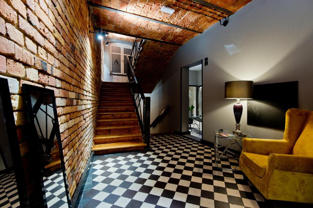 a living room with a staircase and a brick wall at Apartamenty I SORAU in Żary
