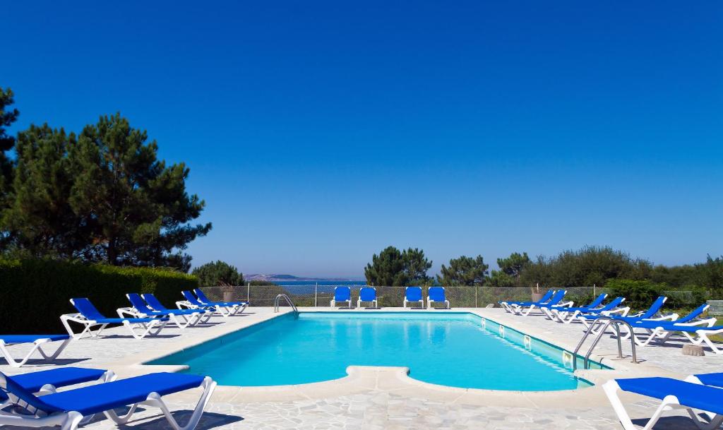 una piscina con tumbonas y mucho en Duerming San Vicente Hotel, en San Vicente do Mar