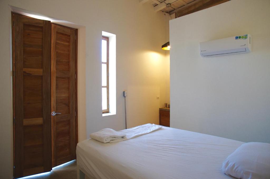 a bedroom with a bed and a wooden door at Casa Tunido in Santa Marta