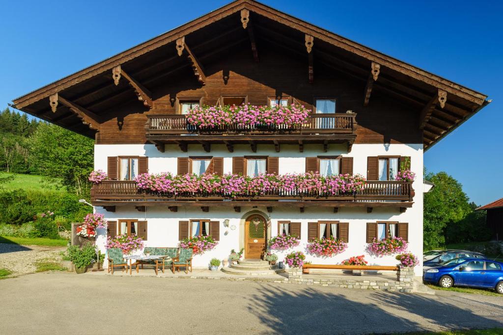 a house with a balcony with flowers on it at Schmuckhof in Siegsdorf