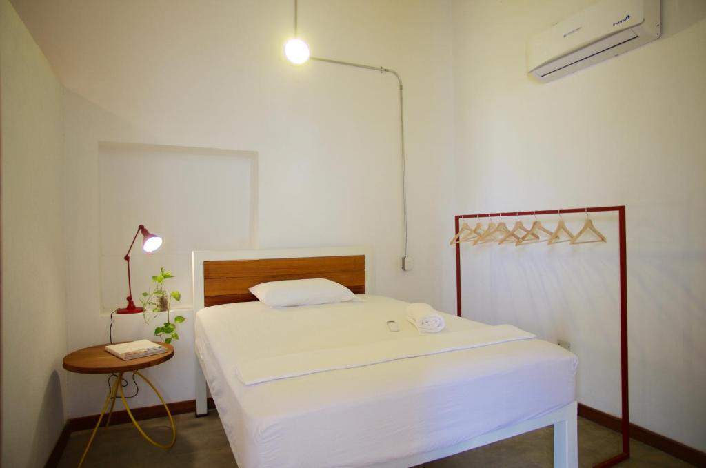 a bedroom with a bed and a lamp and a table at Casa Tunido in Santa Marta