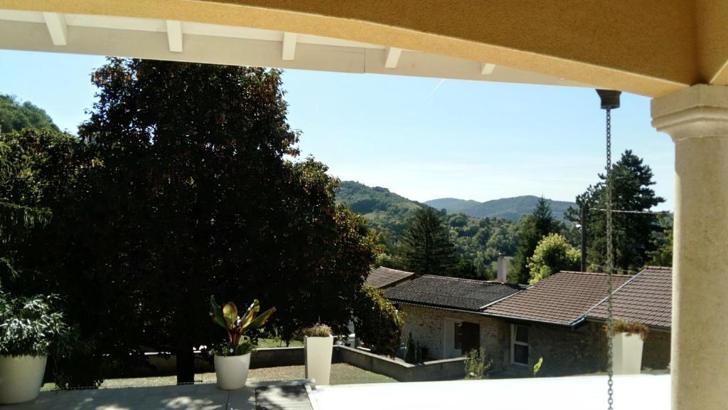 Vistas a una casa con montañas en el fondo en L'Esthélio Gîtes ou L'Esthélio Spa avec Jacuzzi et Sauna, en Ambérieu-en-Bugey