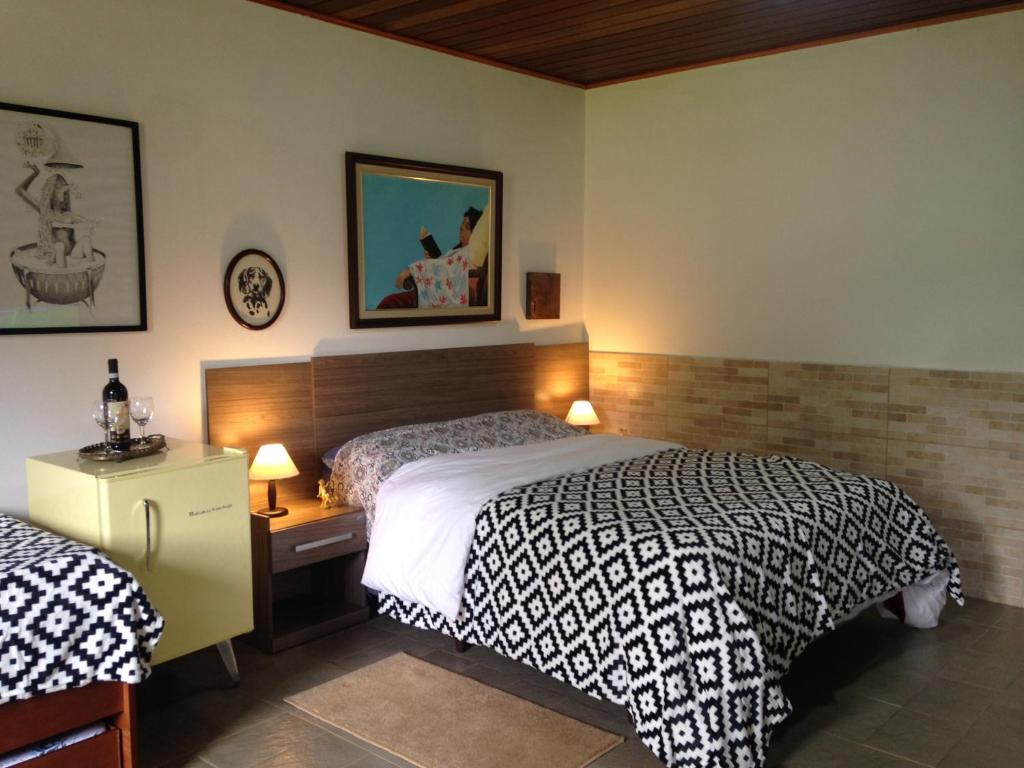 a bedroom with a bed and a desk with two lamps at PIccolo Borgo Antico - Rifugio del Falco in Campos do Jordão