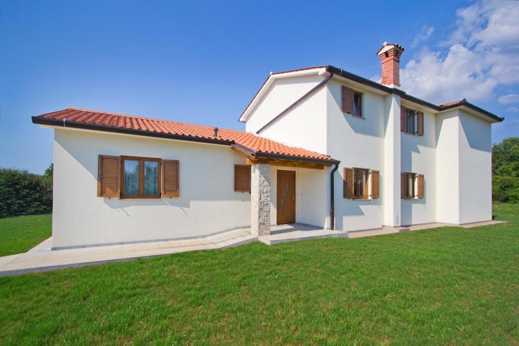 a small white house with a grass yard at Villa Mattina in Nedeščina