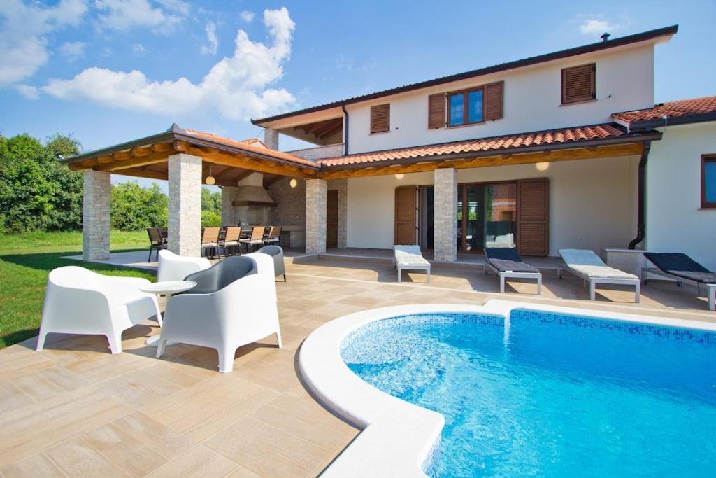 a backyard with a swimming pool and a house at Villa Mattina in Nedeščina