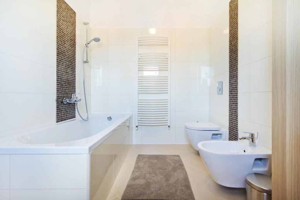 a bathroom with a tub and a toilet and a sink at Villa Mattina in Nedeščina