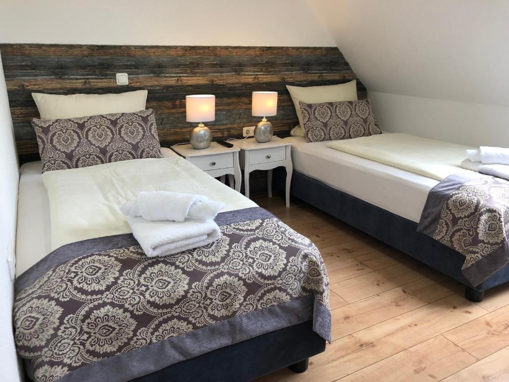 2 Betten in einem Zimmer mit 2 Lampen an Tischen in der Unterkunft Hotel La Musica in Glessen