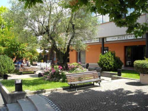 a park with a bench in front of a building at Hotel La Corte in Rubiera