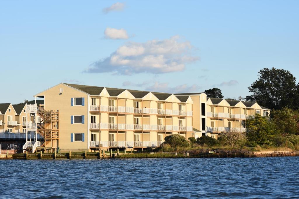 um grande edifício de apartamentos ao lado de um corpo de água em Waterside Inn em Chincoteague