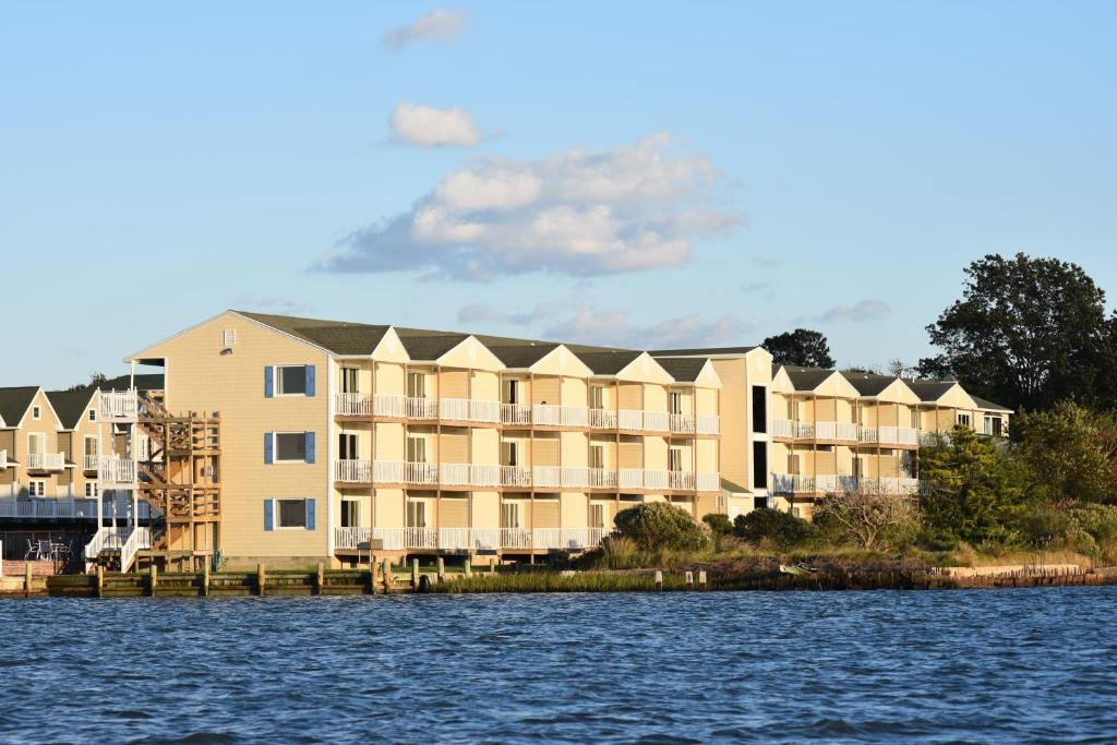 a large apartment building next to a body of water at Waterside Inn in Chincoteague