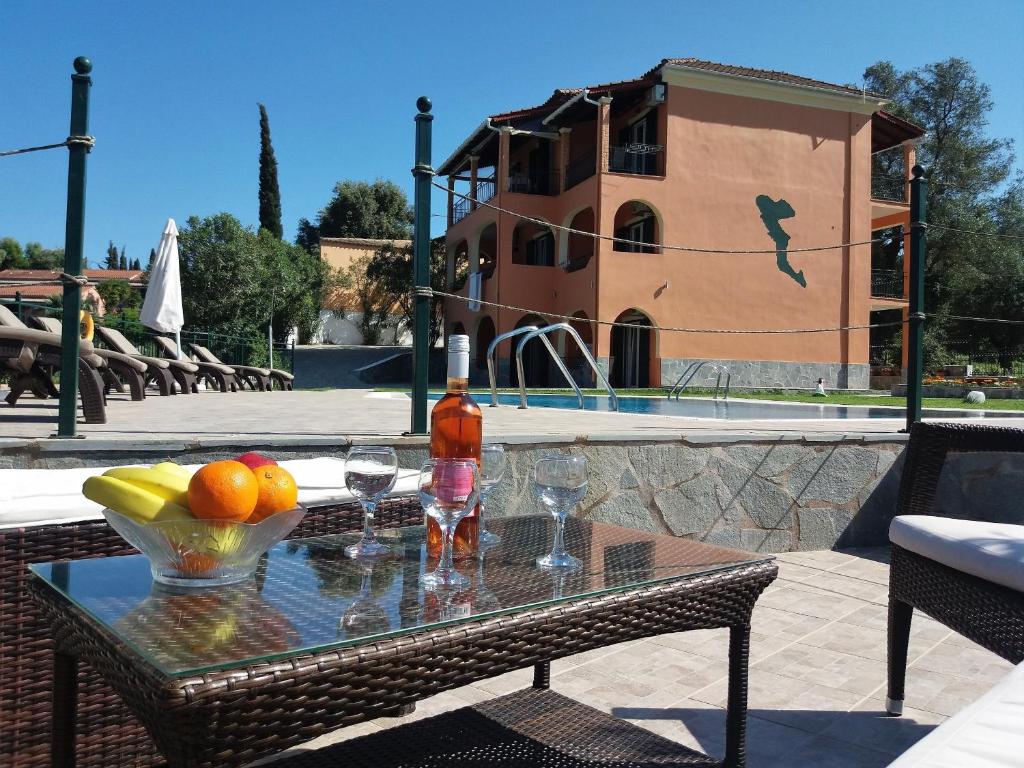 a table with a drink and fruit on it next to a pool at Ziogas Luxury Apartments in Dassia