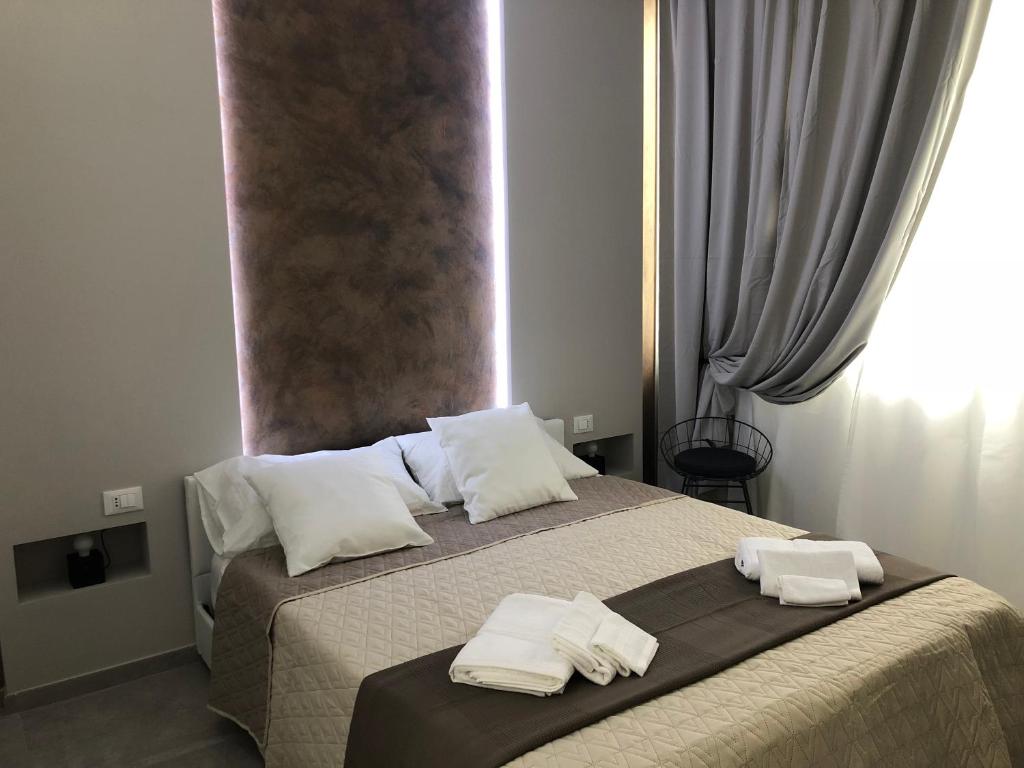 a bedroom with a bed with two towels on it at Turin Central Rooms in Turin