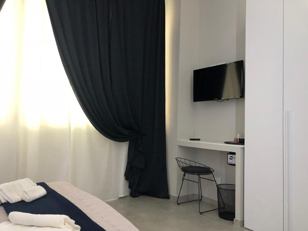 sypialnia z łóżkiem z czarną zasłoną w obiekcie Turin Central Rooms w Turynie