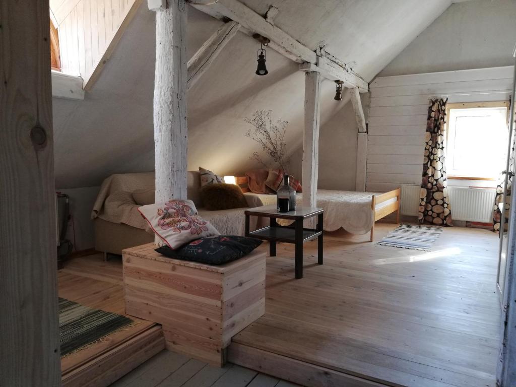 セイニにあるDwór Łumbieのベッド1台とソファ1台が備わる屋根裏部屋